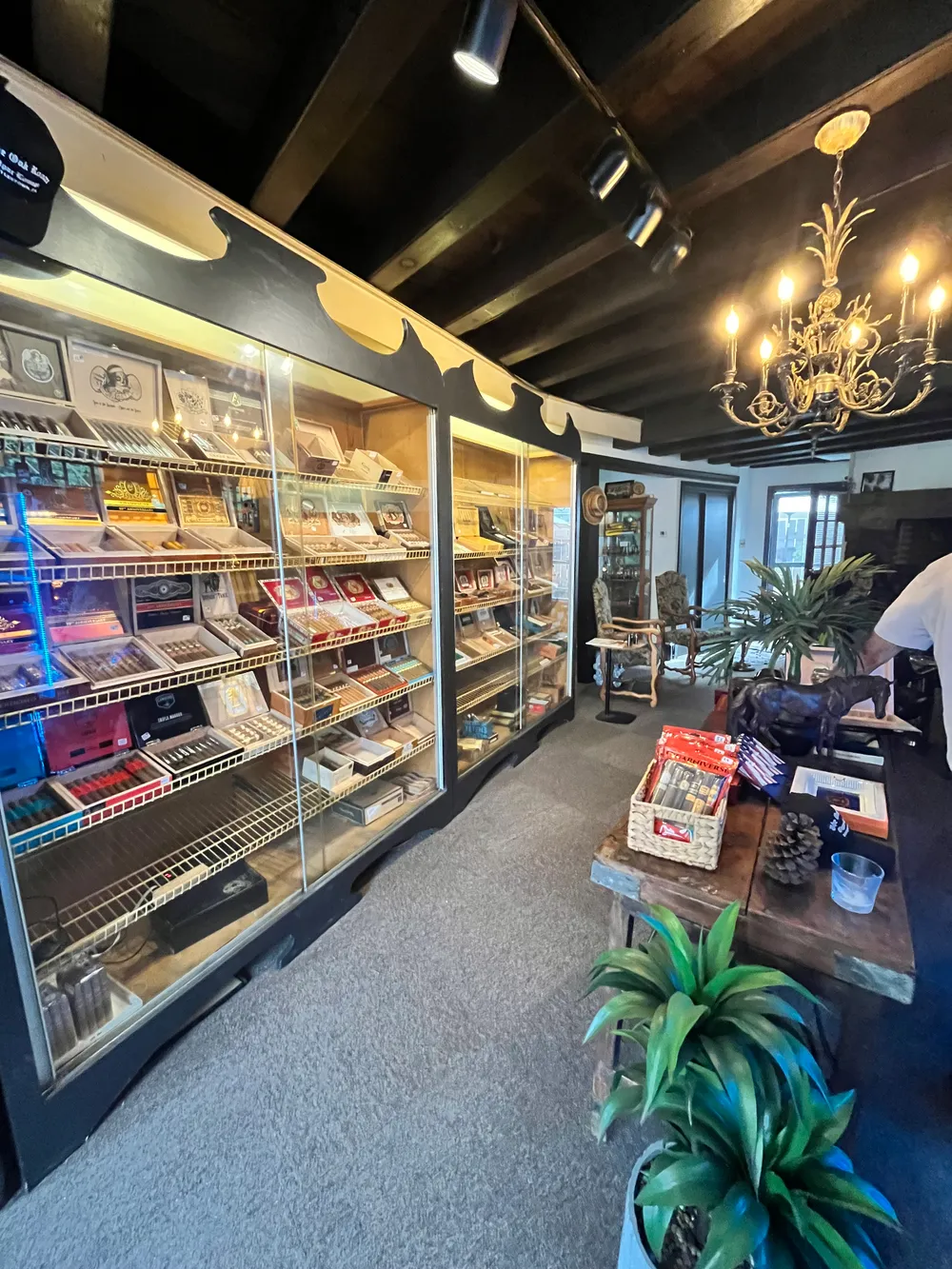 The humidor room, with lit display cases of cigar boxes under a brass chandelier