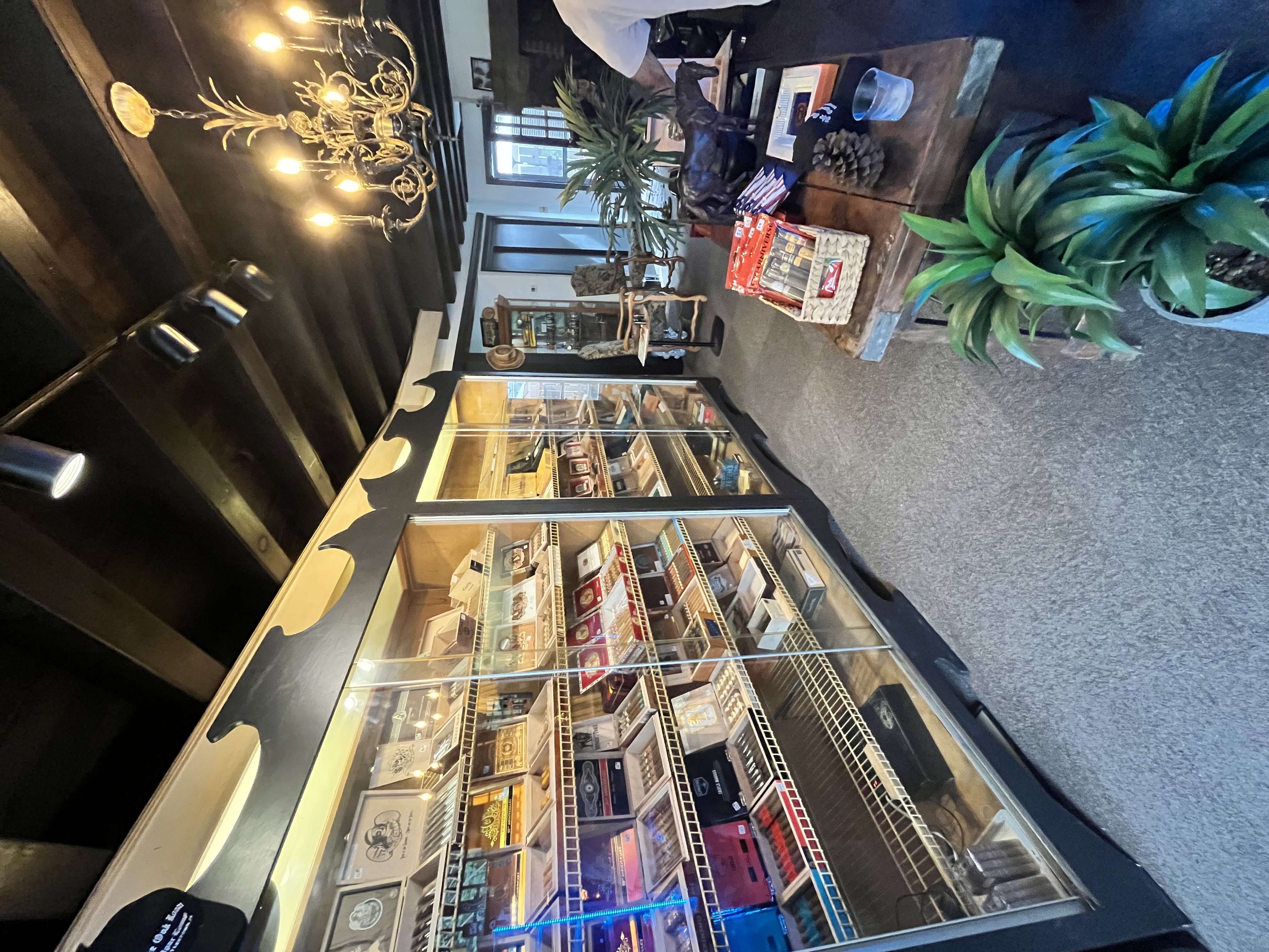 The humidor room, with lit display cases of cigar boxes under a brass chandelier